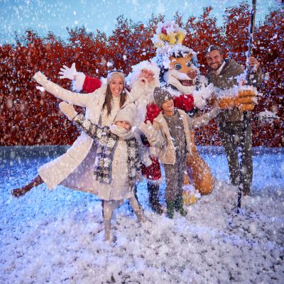 Een gezin beleeft samen met de kerstman plezier in de sneeuw in Bellewaerde Park.